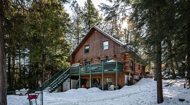 wooden cabin in a forest and surrounded by snow